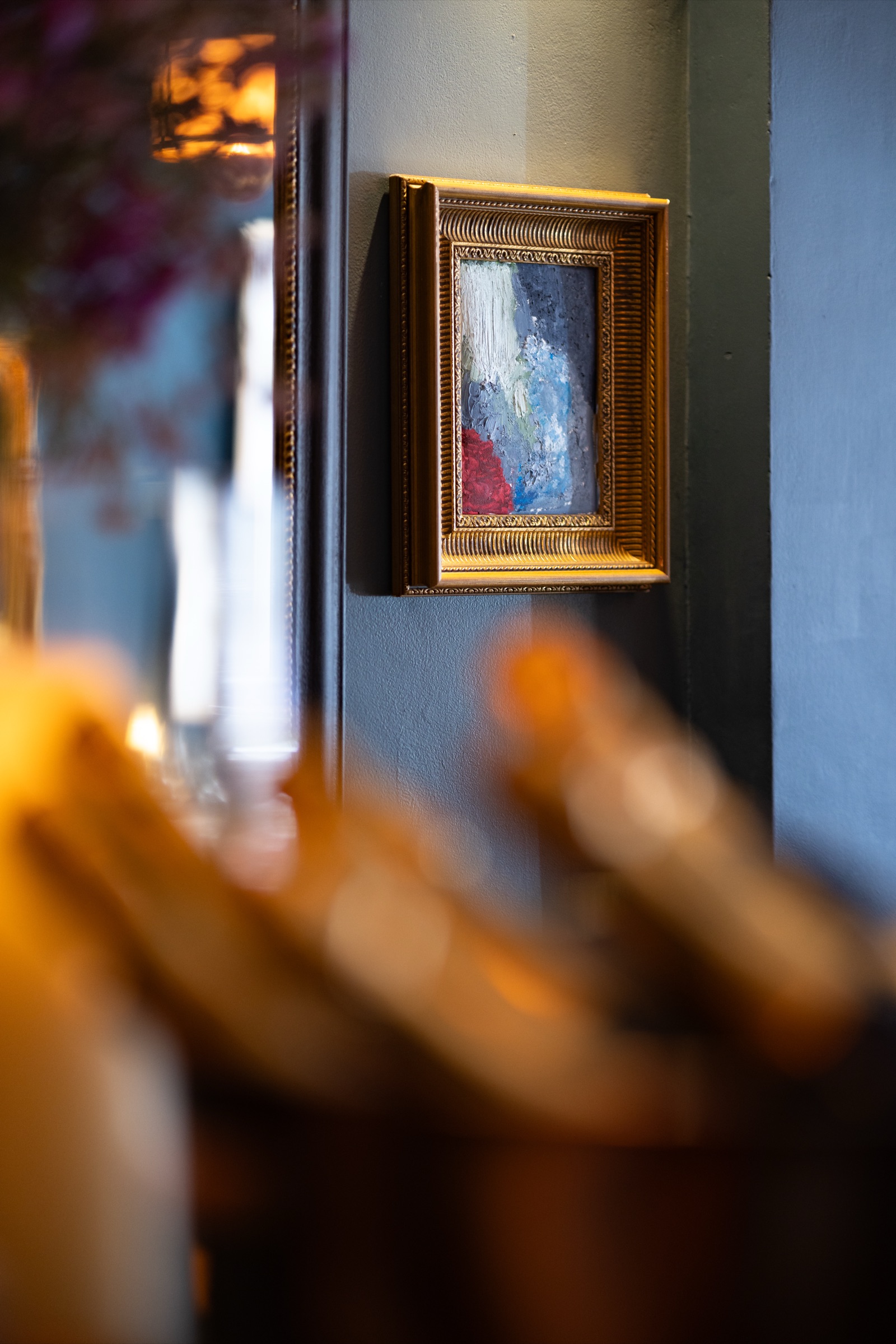 Gold-framed artwork on teal walls